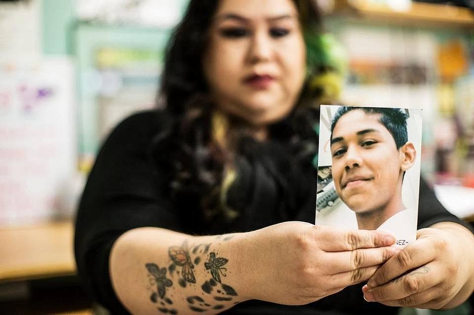 Winton resident Claudia Gonzalez, 29, holds a photo of a friend who was killed by gang violence while speaking about her childhood and experience being initiated into a gang at the Merced Organizing Project office.