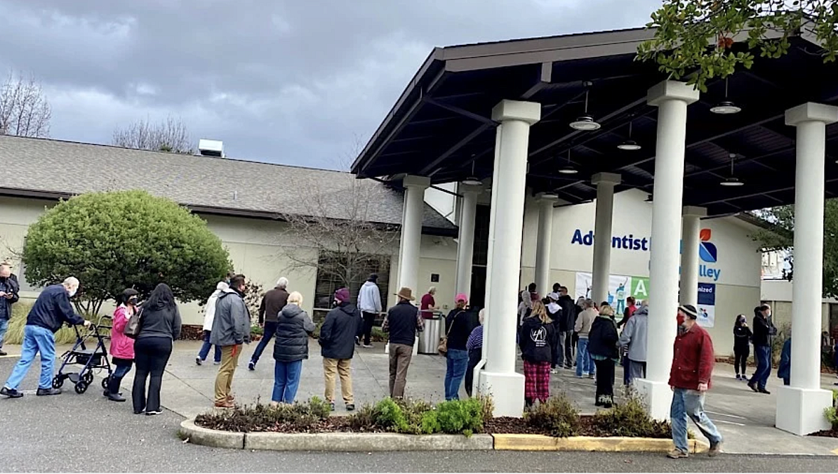 Gente hace fila afuera del Centro Médico Adventist Health Ukiah Valley para conseguir una vacuna de Moderna COVID-19 durante una