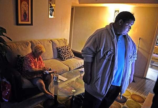 Deonta Ridley watches TV while his grandmother, Nellie Diaz, fishes around in her purse for money so he can go to the store to get them a snack. Diaz has diabetes, and Deonta learned last year that he has elevated cholesterol and is at risk for developing diabetes. / Larry McCormack / The Tennessean