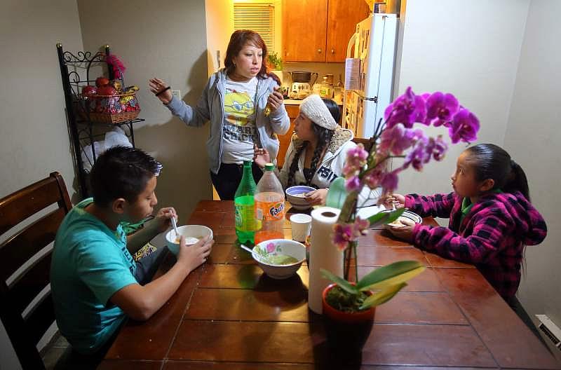 Karla Orozco talks with her children, Jobani, 12, left, Janet, 15, and Jacquline Sanchez, 7 as they eat breakfast Jan. 19, 2015 in their apartment at the Bennett Valley Townhomes complex. Families living in the ten-unit Hoen Avenue apartment complex were plagued by rodent and cockroach infestations, dangerous levels of mold, and other substandard conditions. The city later last January forced residents to vacate the complex, Orozco and her family have moved to another apartment in Santa Rosa.