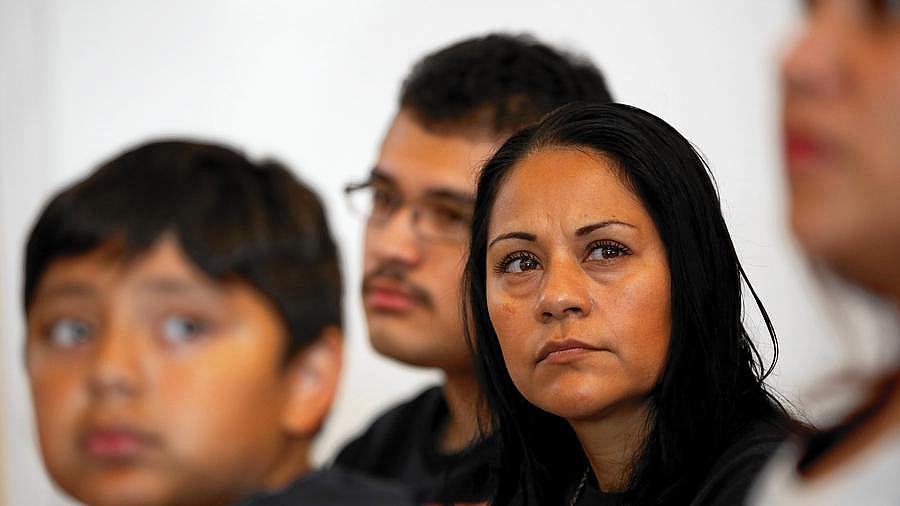 Sujey Becerra, an uninsured immigrant living in San Bernardino County, was unable to pay for the removal of ovarian cysts and now lives in constant pain after emergency surgery. She's shown with her sons Alexandre, 10, left, and Gonzalo Cervantes, 16. (Irfan Khan / Los Angeles Times)