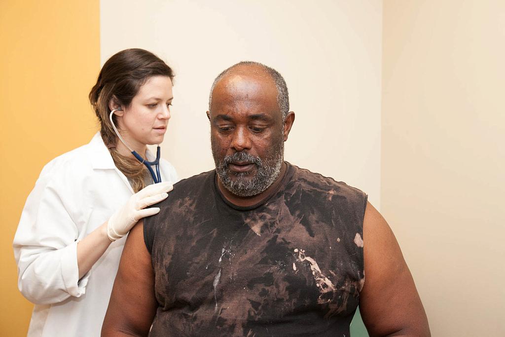 Samantha Smith checks on 58-year-old patient Paul Shelton. He has severe liver scarring as a result of hepatitis C, but his insurance company has denied his request for treatment at least twice. Susanica Tam for KPCC