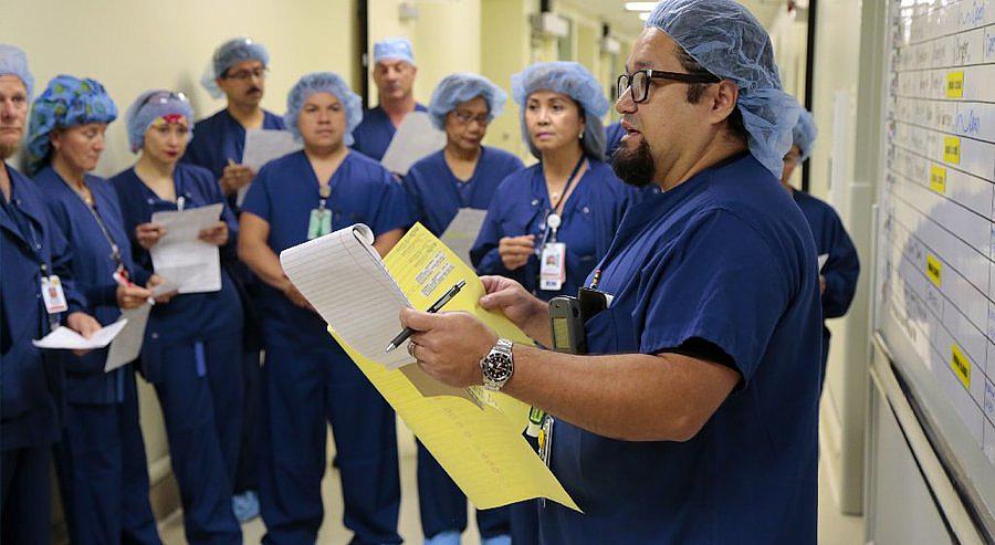 Sam Minero, manager of surgical care at Sharp Memorial Hospital, runs through the daily schedule with the nurses, technicians and other workers who staff the facility's surgical department. — Howard Lipin Sam Minero
