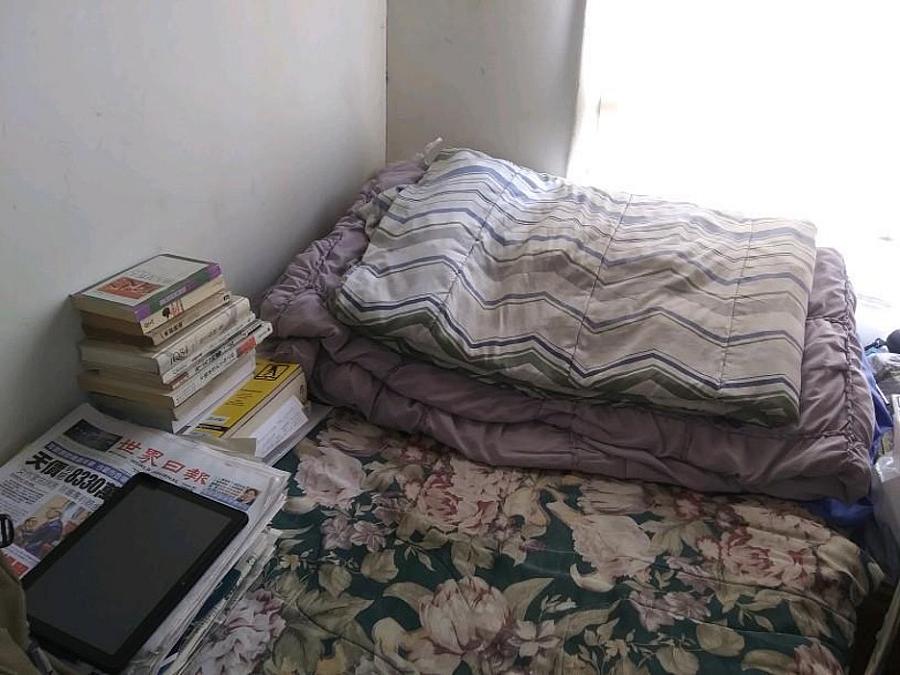 A wooden board separates Yuan Yuang's bed from his neighbor's