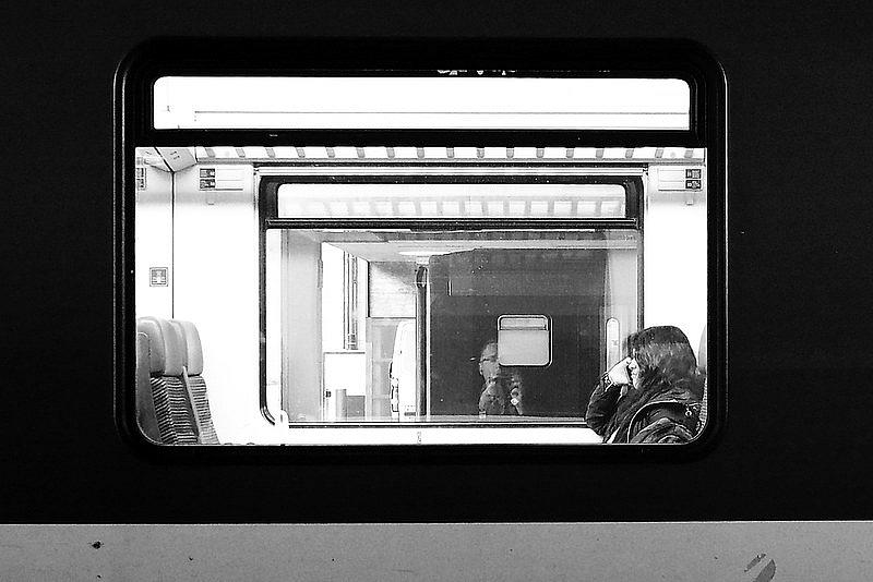 Image of a person sitting in a train looking out from window