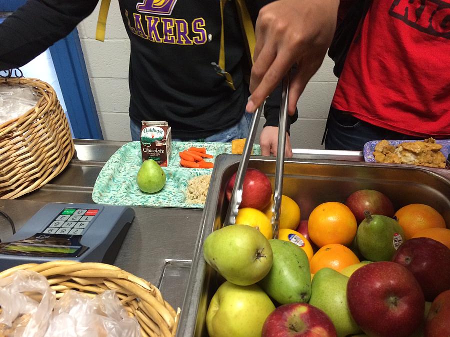 A student goes for a healthier item during lunch at Lewiston High School Cafeteria in Maine, while chocolate milk lurks in the background. (Photo by Patty Wight)