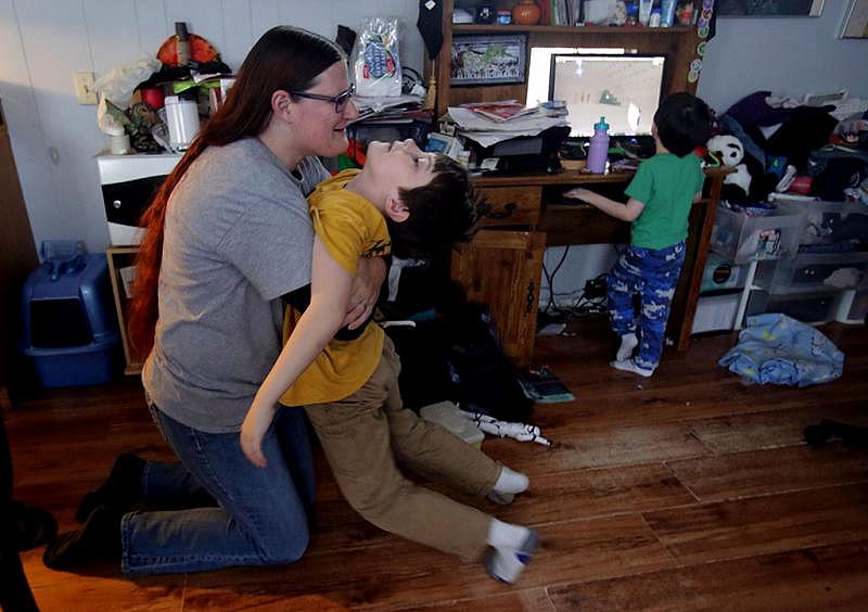 “I love you. You need to get your shoes on so we can leave soon,” says Ruth Coleman as she hugs her son Dylan, 8, at home in Truesdale in January. She was urging him to get dressed so they would be on time for family night at her younger son’s Early Head Start preschool.
