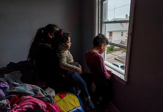 Image of a person and two children looking out of window
