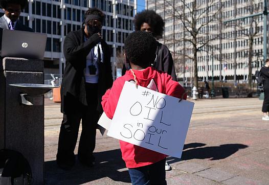 A young boy wears a sign outside of City Hall, protesting the construction of the Byhalia Connection Pipeline, Tuesday, Feb 23