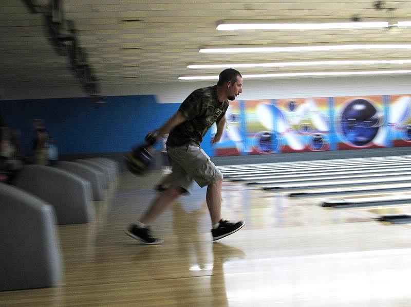 Ben Lingle aims a bowling ball in Redding, California. He and his family had to evacuate their home due to the Carr Fire last ye