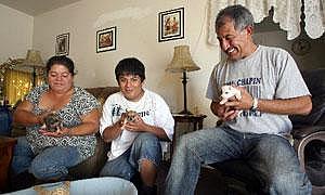 Calixto Orantes, right, his son Julio, 17, center, and wife Edel, left, play with their new puppies at their home.