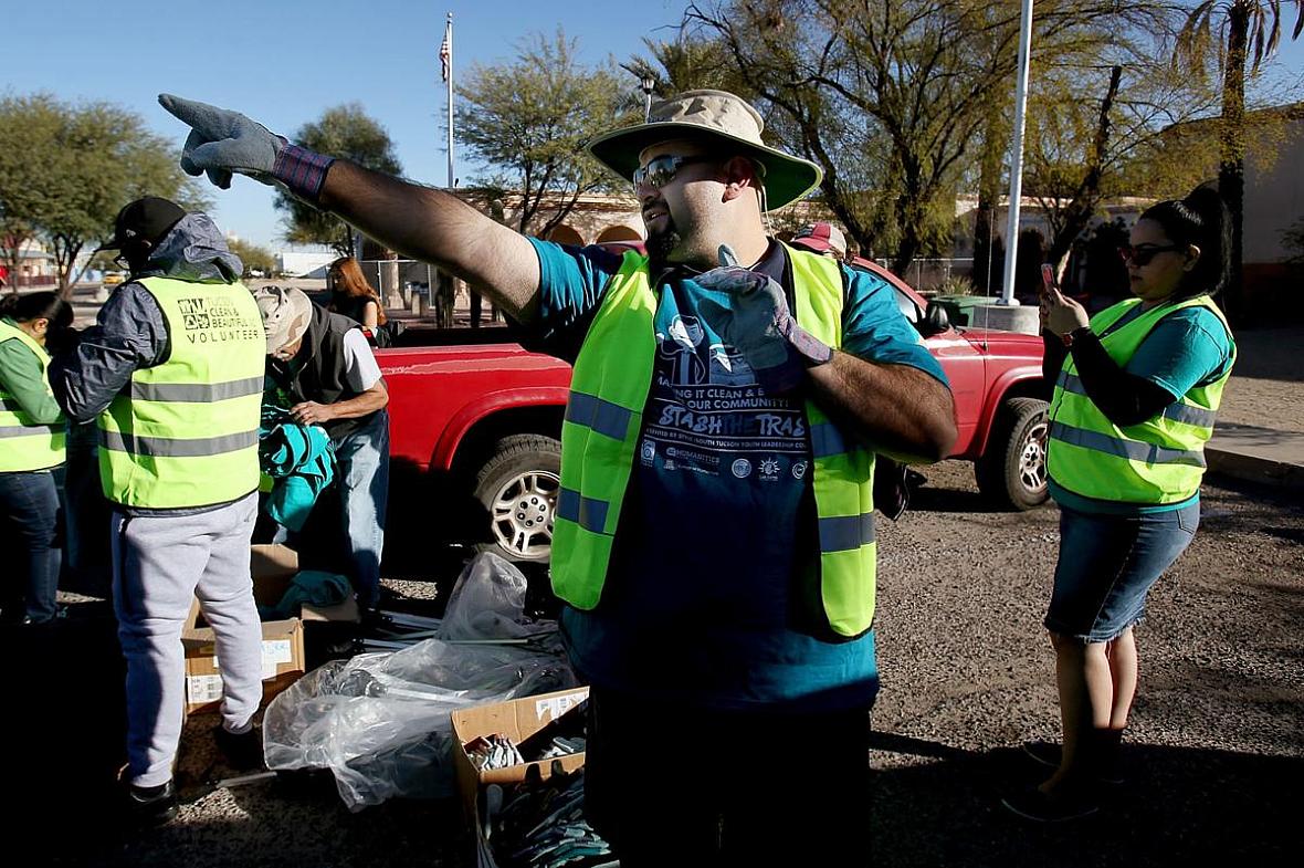 Lorenzo Gonzalez, head of the Healthy South Tucson Coalition, directs a trash cleanup on South Sixth Avenue, an area of concentr