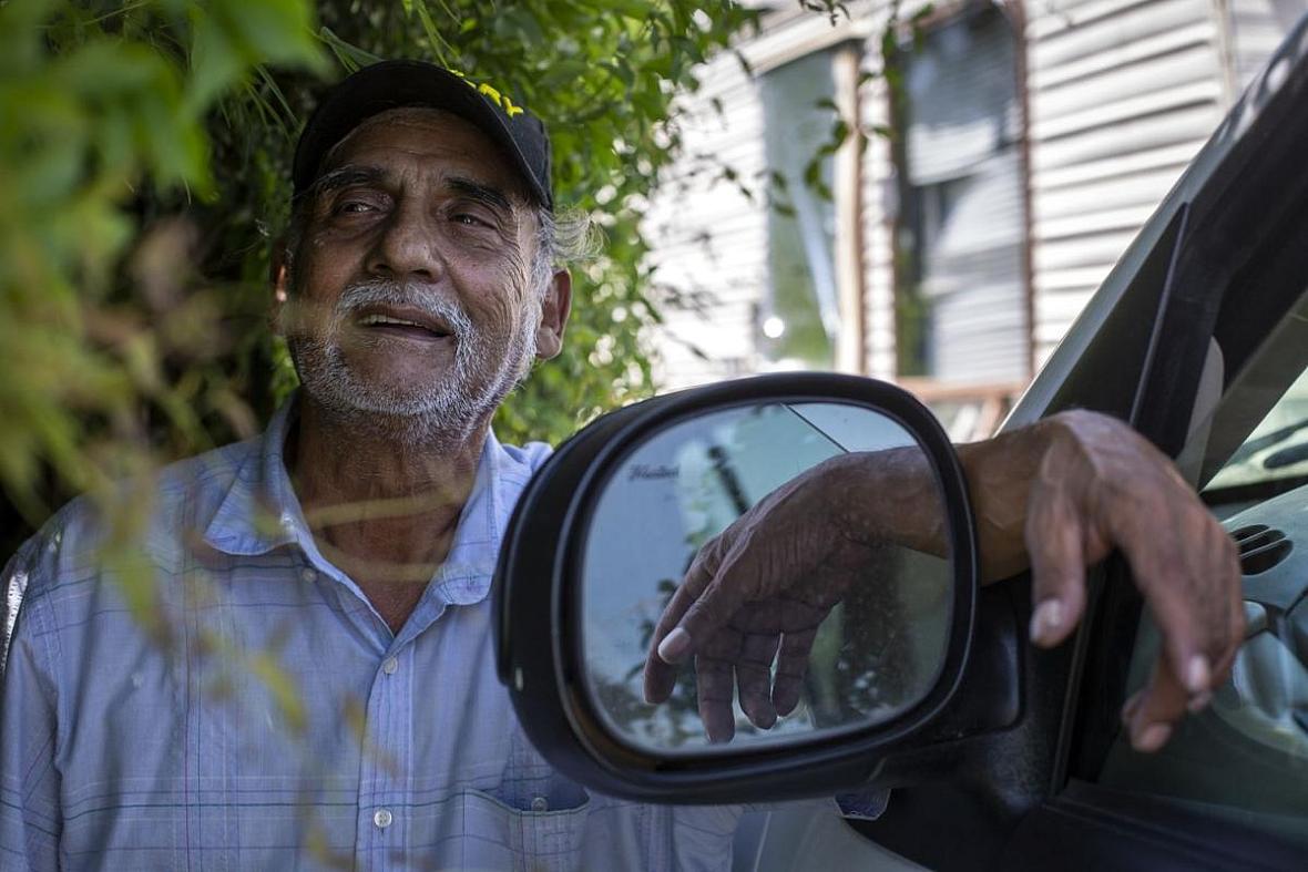 Reynaldo Garza leans against his 2002 Ford Expedition. The 70-year-old purchased the SUV to escape from the heat and and have a 