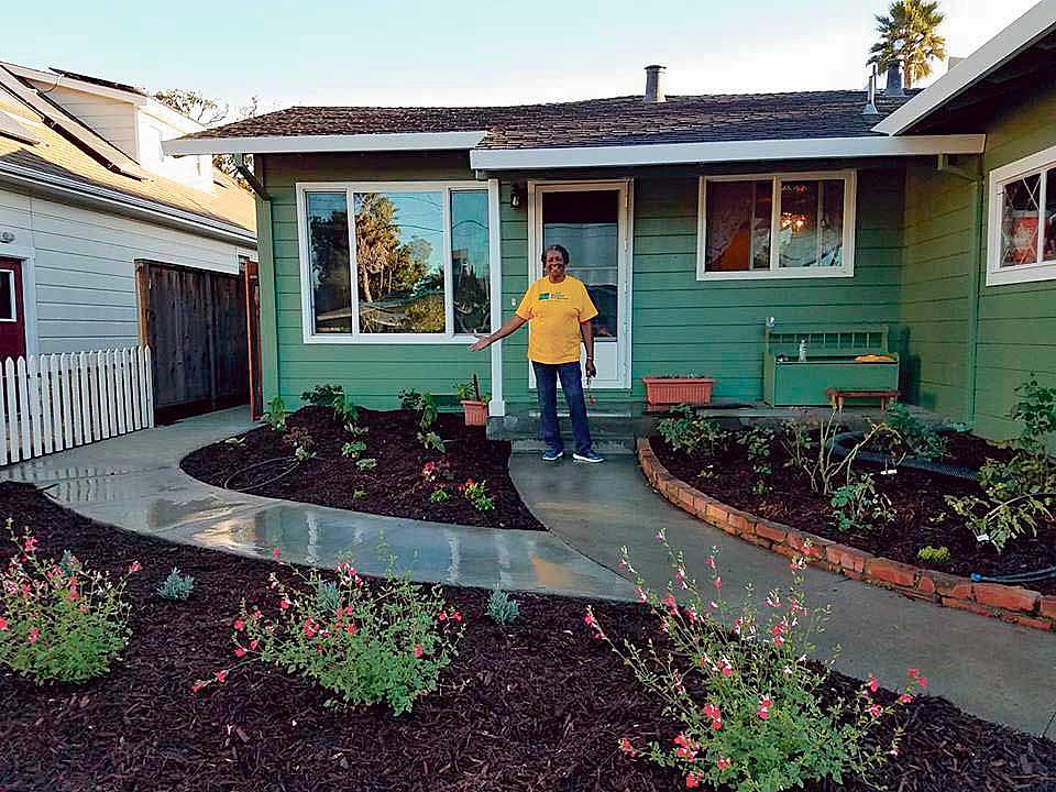 Carrie Whitley shows off a new garden in front of her Santa Cruz home. Habitat for Humanity Monterey Bay helped add a 500-unit A