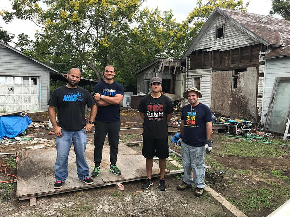 Amilcar Heredia, Eduardo Assef, Robert Santos and Isaac Fonseca stand outside Reynaldo Garza’s home after cleaning up debris in 