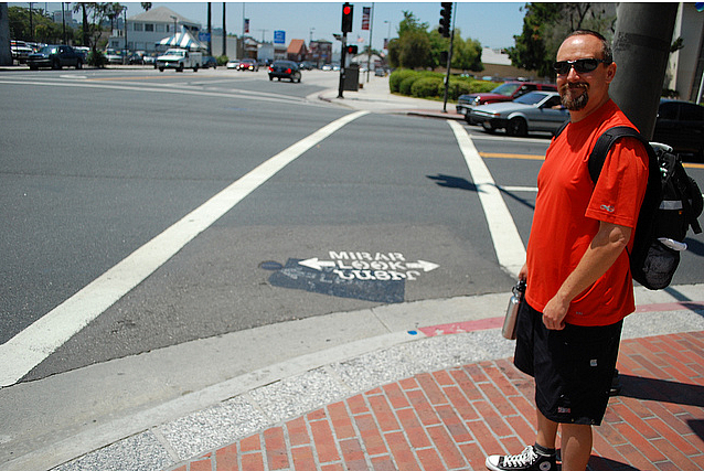 Glendale PLACE Grant Coordinator Colin Bogart shows off the new tri-lingual pedestrian safety markings at an intersection adjace