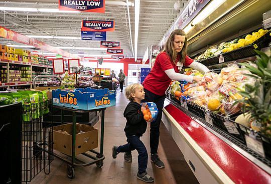 Jenny Kute and four-year-old son Henry put out fresh produce at the family's Save-A-Lot on Taylor Boulevard in the Hazelwood neighborhood of Louisville. Kute and husband Craig Oeswein had tailored the store to offer international foods for its customers as well as farm-to-store produce in the summer months. There is a farm behind the store's back lot that grows vegetables and the owners sell it at the store. Jenny Kute and four-year-old son Henry put out fresh produce at the family's Save-A-Lot on Taylor Boulevard in the Hazelwood nei