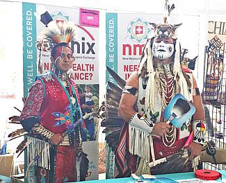 Two dancers in regalia work a Native American Professional Parent Resources outreach booth at the 2014 Gathering of Nations powwow in Albuquerque, N.M. | Courtesy Photo