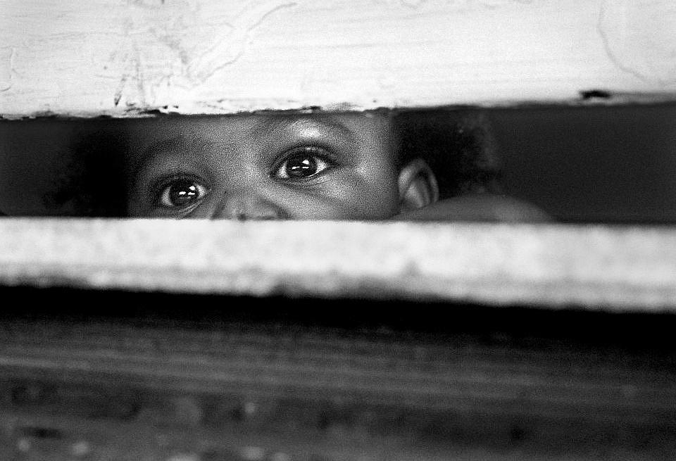 One-year-old CJ watches out the window as his older siblings, Skylar and Jaylen play in the front yard with his cousin.