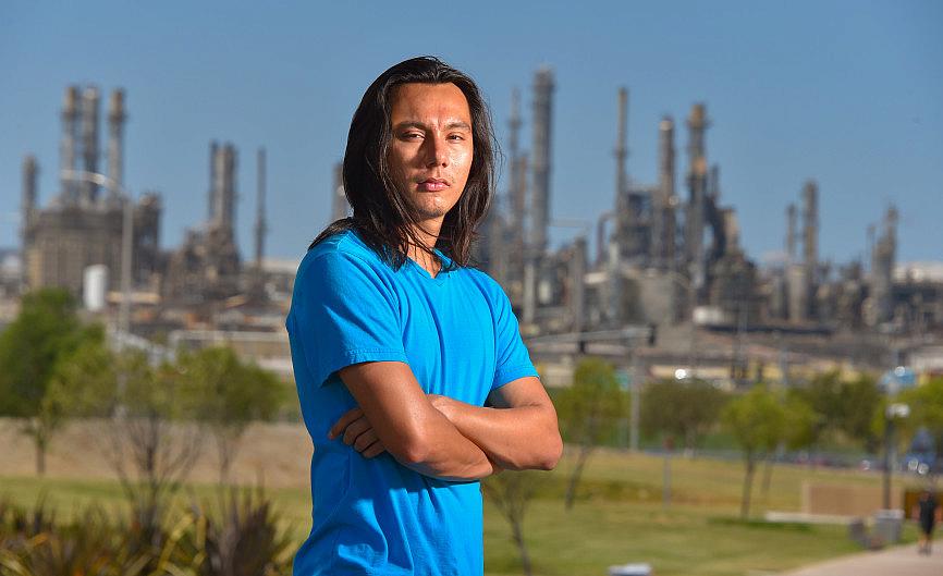 With the ConocoPhillps refinery behind him, Nick Serrano stands in the Wilmington Waterfront Park in Wilmington on Friday, Aug.