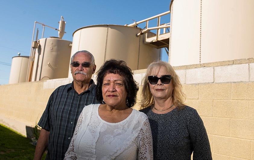 Florencio Flores left, and his wife Diane Flores, center, stand in their backyard along with neighbor Theresa Rodriguez with a v