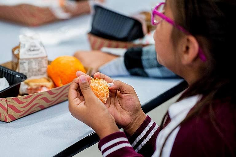 A student eats an orange during lunch at Don Stowell Elementary School in Merced, Calif., on Tuesday, May 14, 2019. 