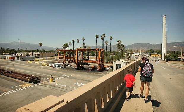 A women and child walk along the Mt Vernon bridge that goes over the BNSF Railway San Bernardino Yard on Friday, August 23, 2013 in San Bernardino. STAN LIM/STAFF PHOTOGRAPHER