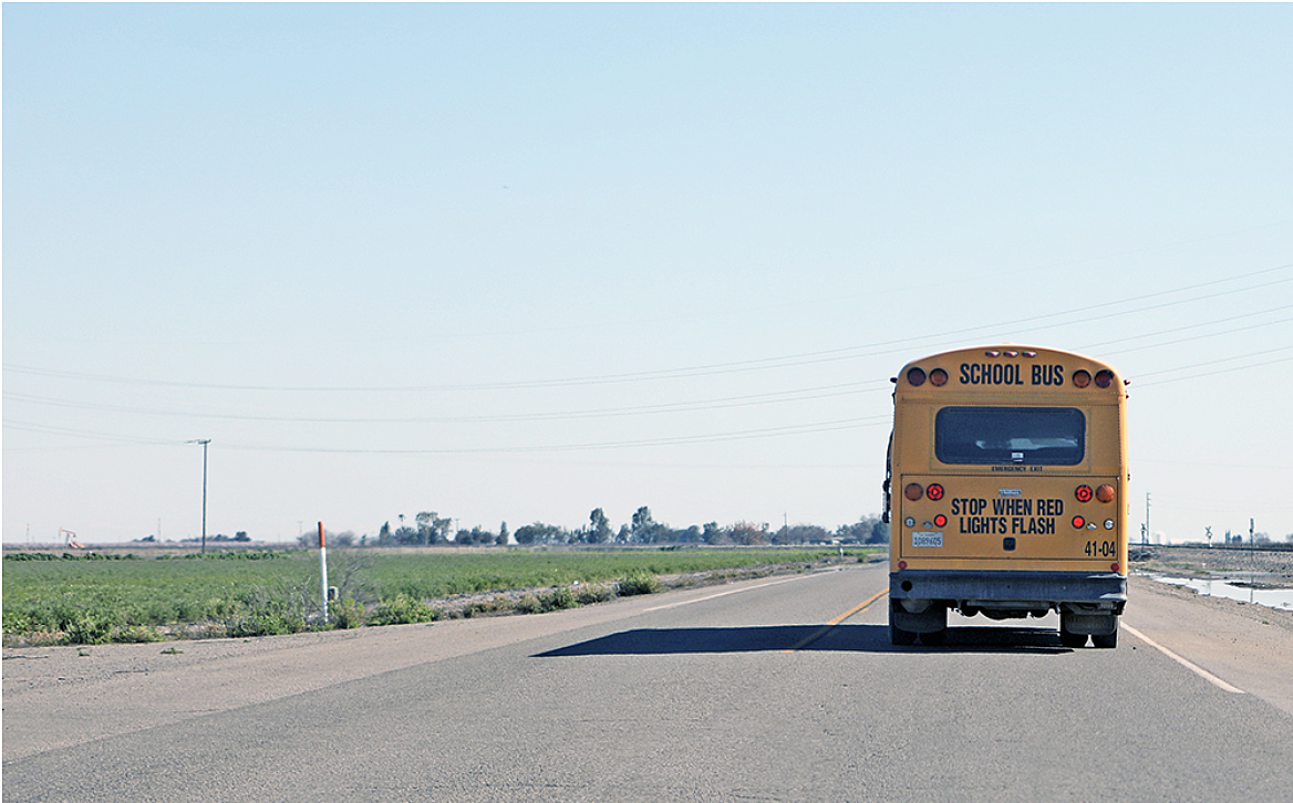 A rural school bus heads out to a campus to pick up students.