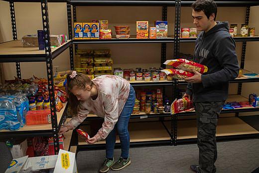 Bellarmine students stow away food items picked up at the Dare to Care food bank to be added to the university’s food pantry. Th