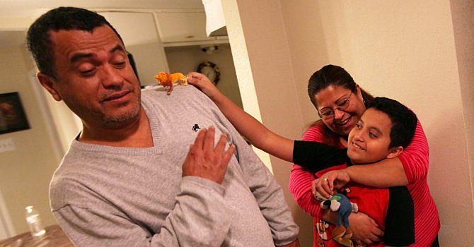 Sofía Ramírez abraza a su hijo Óscar Ramírez mientras juega con su padre y un pequeño juguete en su casa de Dallas. La familia Ramírez ha lidiado con una serie de retos para atender a su hijo, quien fue diagnosticado con autismo. | BEN TORRES/ESPECIAL PARA AL DÍA