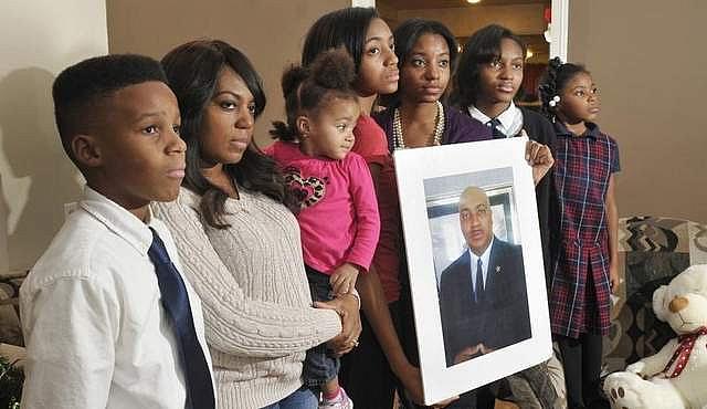 Many families in Detroit must cope with the slaying of a family member. Marcel Jackson was killed while working as a security guard, leaving behind, from left, Tarik, 13; wife Hollie holding Aaliyah, 2; Jala, 16; Najidah, 18; Tamia, 13; and Gwendolyn, 7. (Photos by Max Ortiz / The Detroit News)  