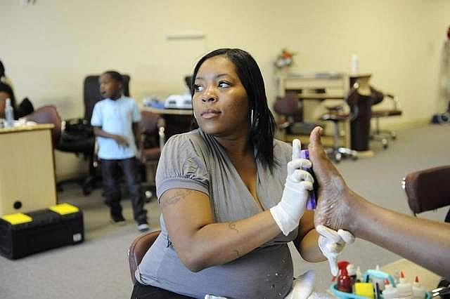 Kanitra Patterson, with her son Robert Jr., age 6, giving a pedicure at Highland Nails in Highland Park. Kanitra Patterson developed a serious heart condition while pregnant with Robert. Doctors said she faces a 50 percent risk of death if she developed that same condition during her current pregnancy. (David Coates / The Detroit News)   