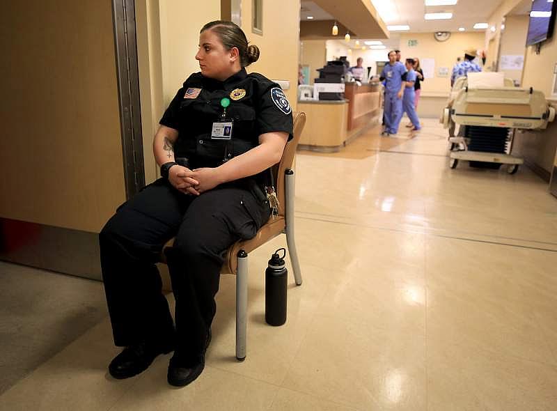 Hazel Brownfield Rosalie of Allied Universal Security keeps watch on a mental health patient in the emergency room.