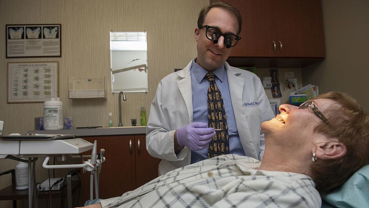 Dentist Richard Vermillion talks to one of his patients, Annie Stoffey of Coaldale, at his Summit Hill office. As doctors and de