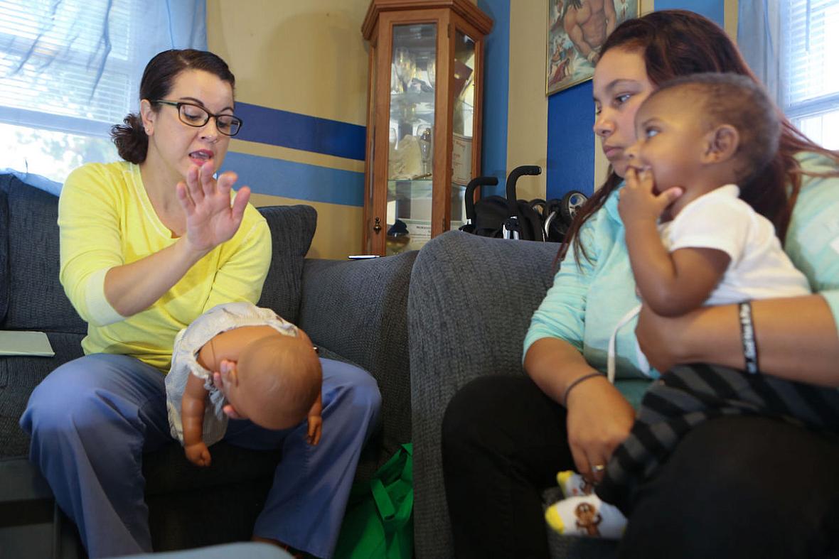 Nurse-Family Partnership nurse Amber Burleson shows D'Ondra Gomes, holding her 6-month-old son, Kai'Dian, what to do if her baby starts to choke. Gomes lives in Indianapolis. Nurse-Family Partnership nurse Amber Burleson shows D'Ondra Gomes, holding her 6-month-old son, Kai'Dian.