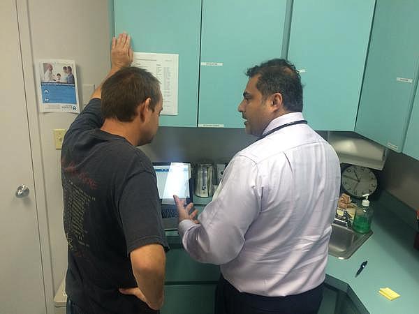 Dr. Ajoy Kumar, right, goes over a patient's blood tests at the St. Petersburg Free Clinic. Julio Ochoa / WUSF Public Media Dr. Ajoy Kumar, right, goes over a patient's blood tests at the St. Petersburg Free Clinic. Julio Ochoa / WUSF Public Media
