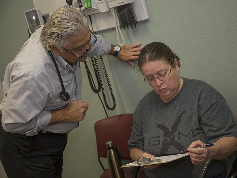 Dr. Ronald Cirillo helps Deborah Hatfield fill out paperwork at a Florida clinic, before running a test to see whether she has hepatitis C. Daylina Miller/Health News Florida Daylina Miller/Health News Florida