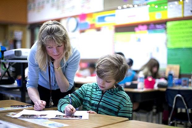 Teacher Ordella Reynolds leads a fourth-grade classroom at César Chávez K-8 School in North Portland, which is affected by heavy student turnover. This year alone, six students have left and seven have joined. On a recent day, she helps student Skylar Woodruff-Quesinberry on an assignment. Beth Nakamura/Staff