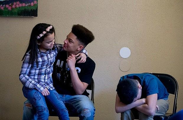 Jaden, left, Jenaya and James inside their Portland apartment. 