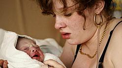 A teen mother who spent most of her life in foster care holds her newborn.