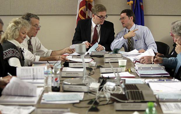 Dr. Sheldon Wasserman, center, chairman of the Wisconsin Medical Examining Board, talks with Tom Ryan, right, executive director of the board. On the left are board members Jude Genereaux and Dr. Gene Musser. The 13-member board, appointed by the governor, includes 10 doctors and three public members. M.P. King