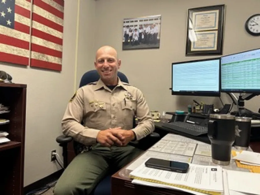 Image of a police officer sitting at his desk