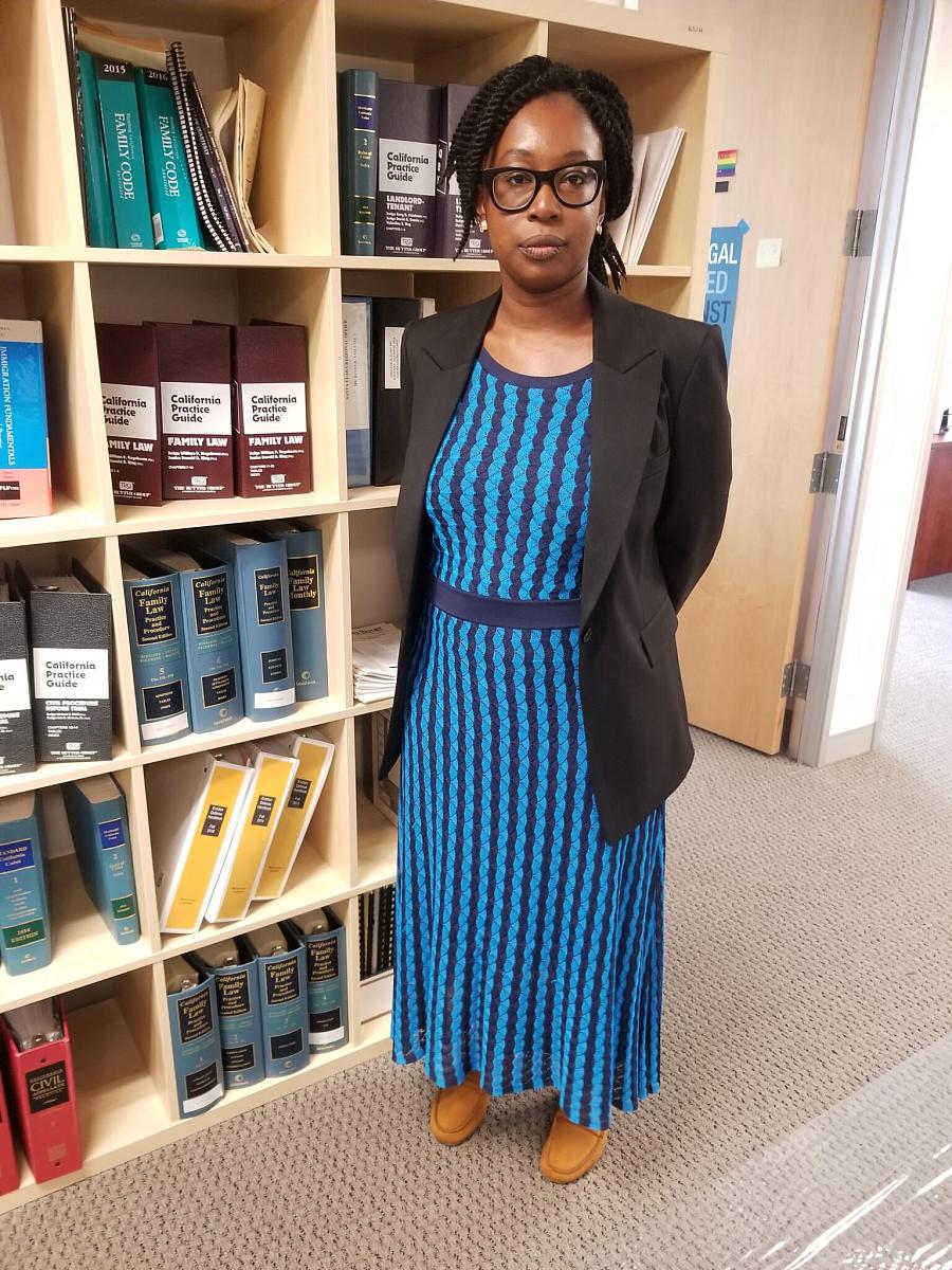 Image of a black woman standing in front of a shelf