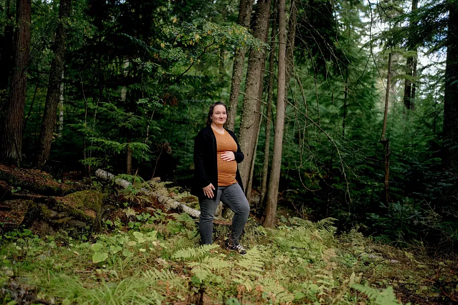 Image of a pregnant woman standing in a forest