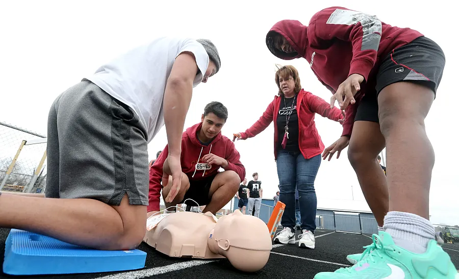 Students performing a sudden cardiac arrest at the track