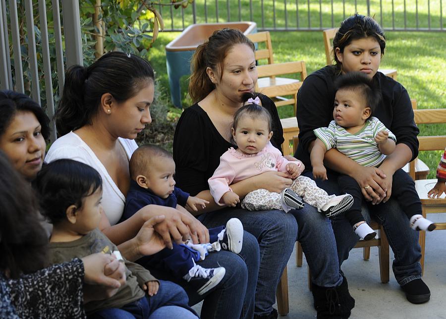 Mothers sit with their babies in their laps.