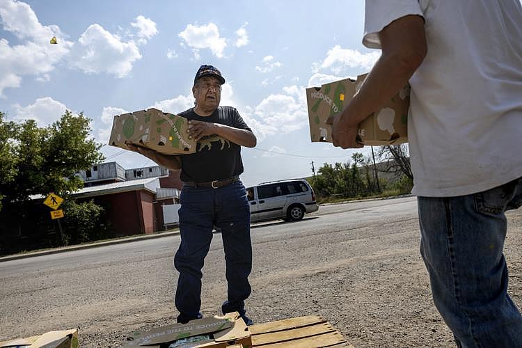 Image of two people carrying a box each