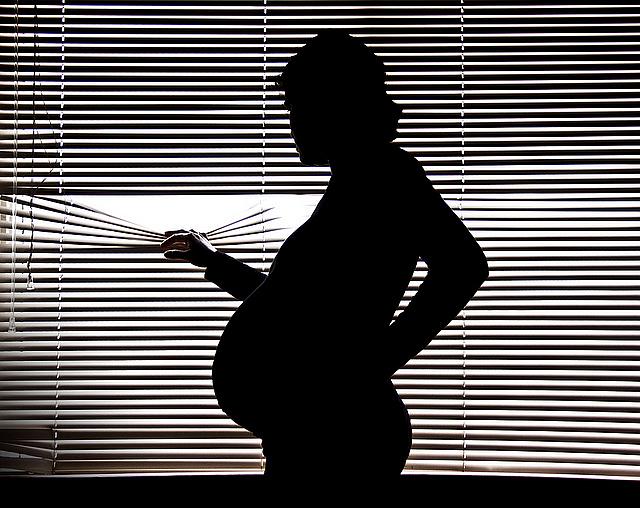 pregnant woman looking out of window