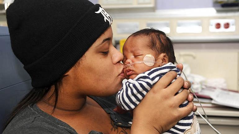 Alaina Gonville kisses her 3-month-old Brandon at the Neonatal Intensive Care Unit at Hutzel Women's Hospital in Detroit. Brandon was born premature through an emergency C-section. (Max Ortiz / The Detroit News) 