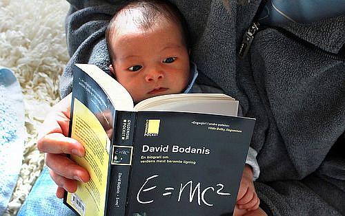 Infant reads a science book. E=mc2